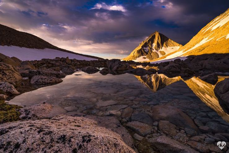 A still mountain lake reflects a tall mountain
