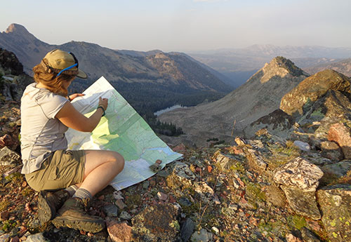 Woman looking at a map in the wilderness