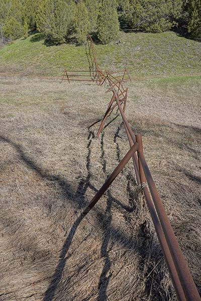 a rusted fence in a dry grassy area with egress
