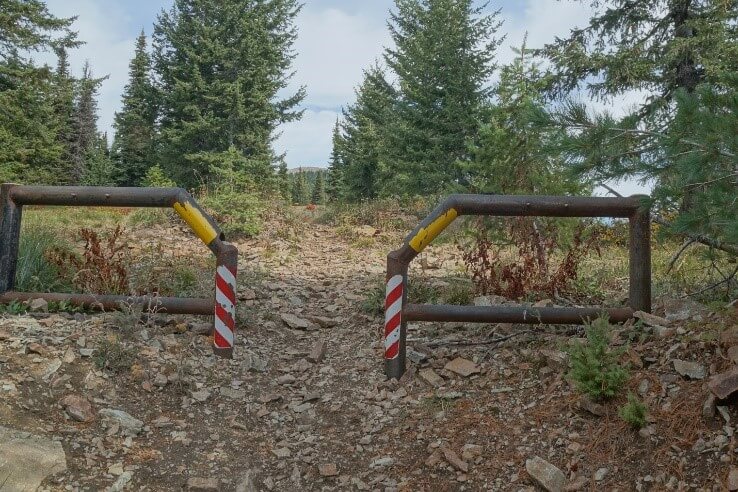 metal fence barrier with space to allow hikers, wheelchairs, and horses through