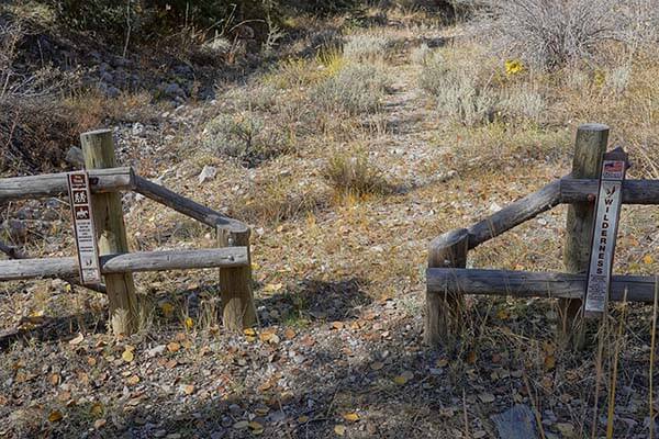 wood fence barrier with space to allow hikers, wheelchairs, and horses through