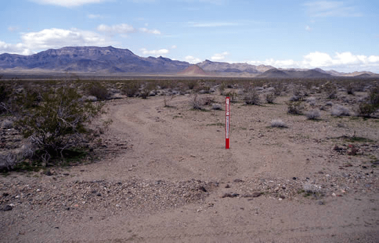 road closed sign on road that is planned to be reclaimed in a desert